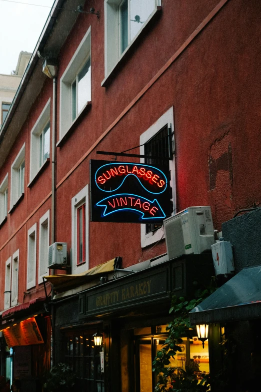 buildings line a city street with shops and neon signs