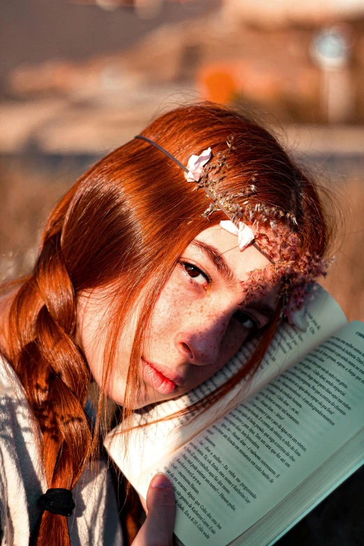 a girl with a red hair and white bow holds a book