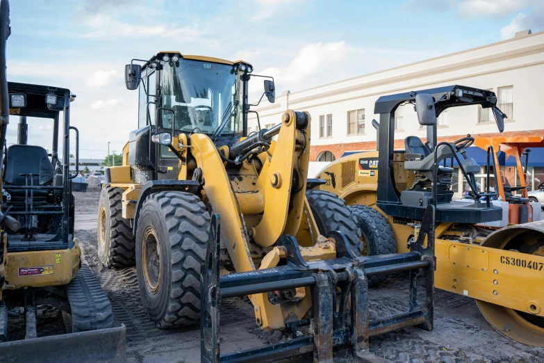 several different type of yellow trucks and fork lift