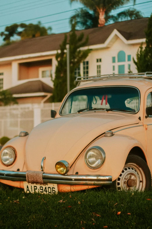 an old pink vw bug parked in front of a house