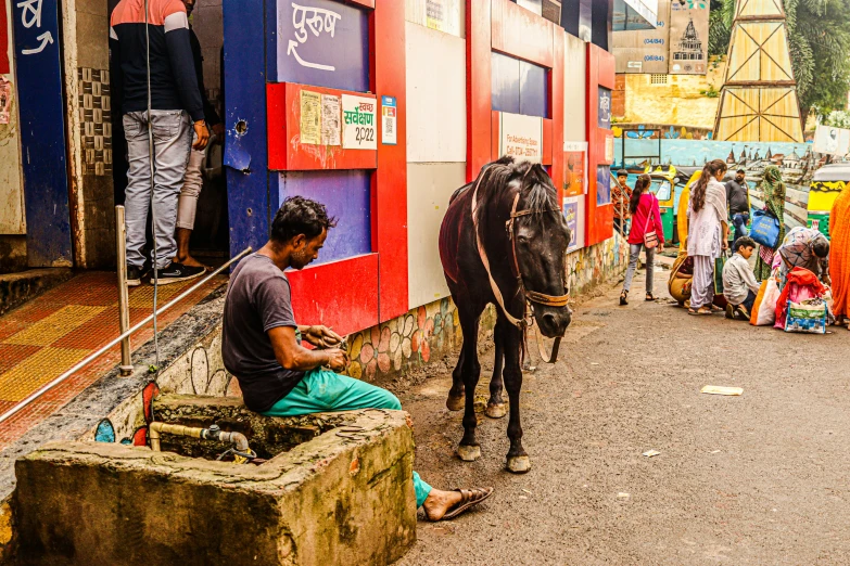 people looking at a horse and a truck in front of a building