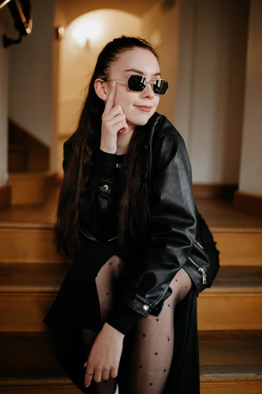 a young woman is posing on a wooden set of steps