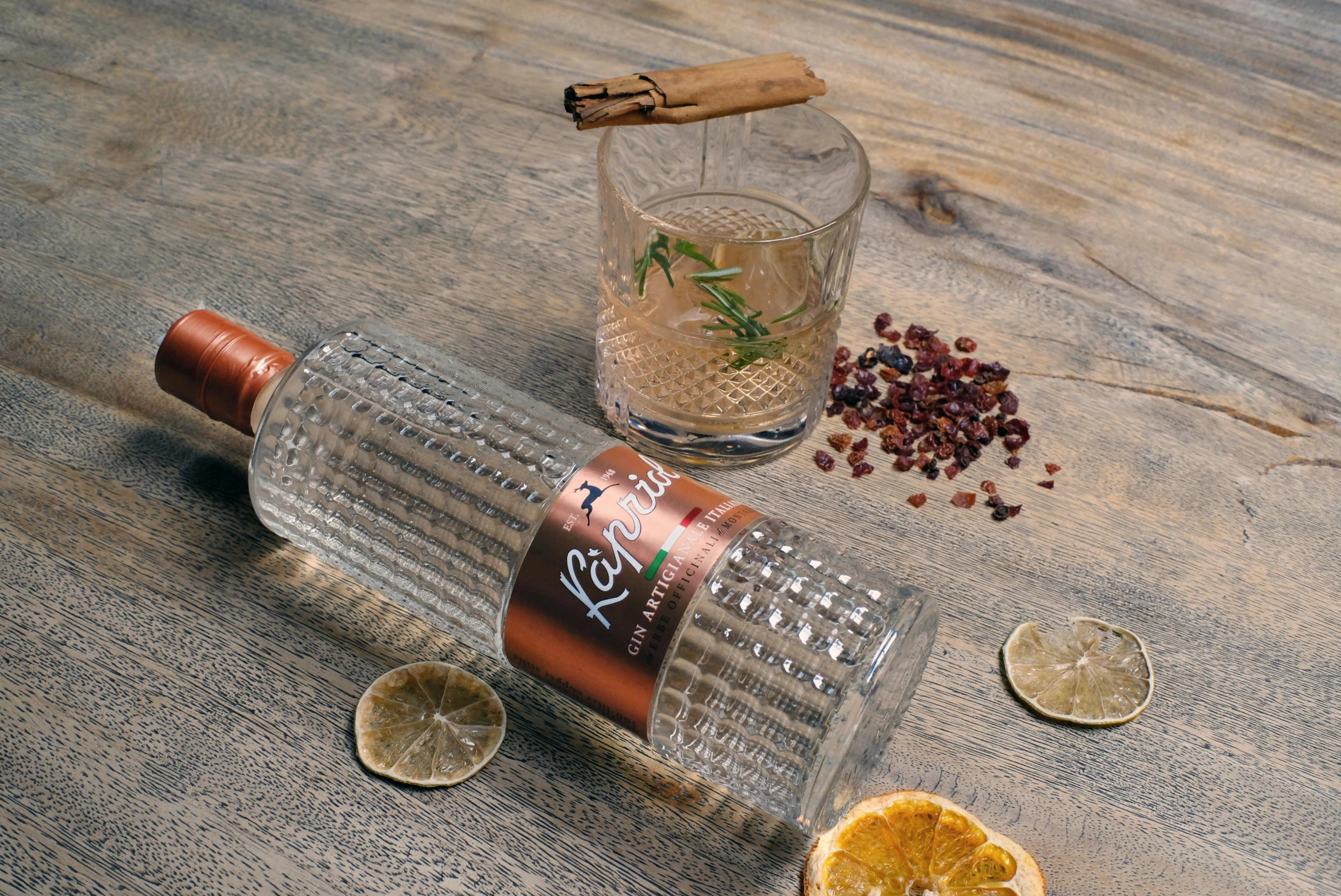 a glass bottle with an orange wedge is next to a bottle of booze