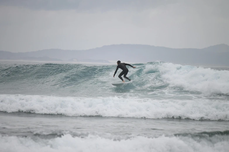 a man riding the waves in the ocean on a surfboard