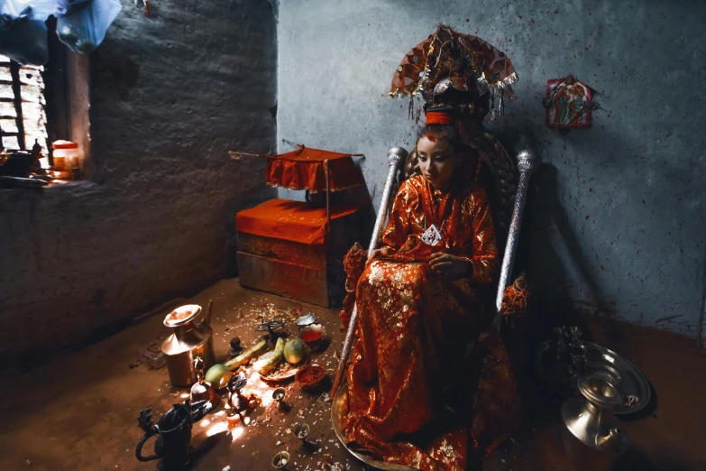 an artistic display of items, including a woman in orange outfit and hat, surrounded by a collection of tools, lights and candles