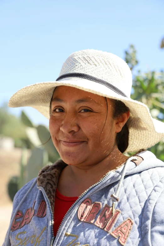 a woman in a hat poses for the camera