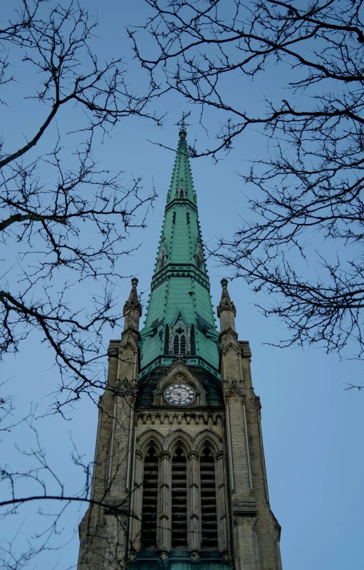 looking up at a tall clock tower with a steeple