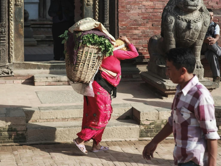 a young child hing a large basket on his back