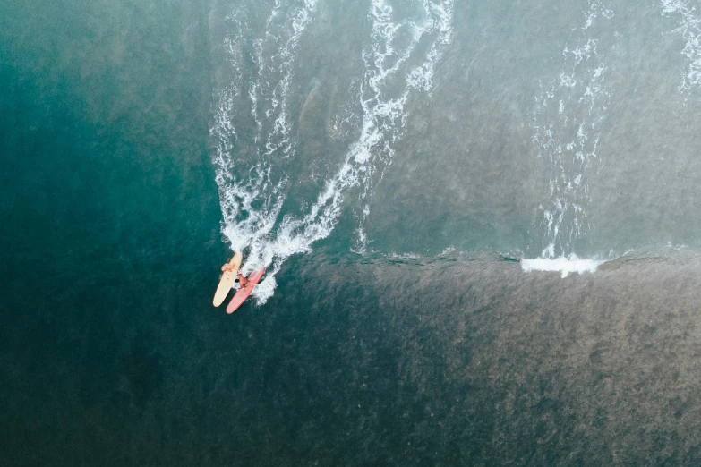 a person riding a board on top of a wave