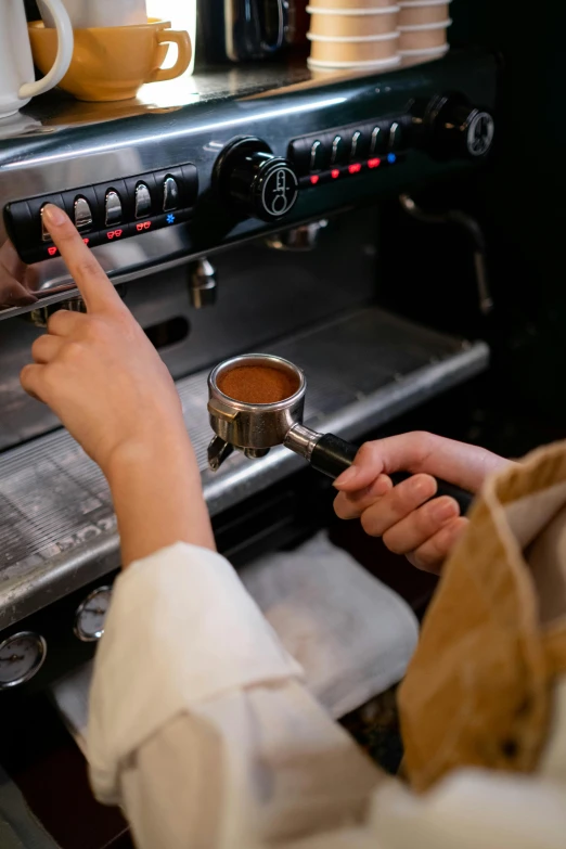 someone pours coffee into the cup from an oven