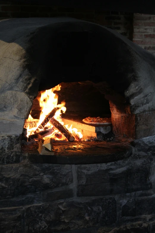 a brick fire oven with some kind of coal cooking it