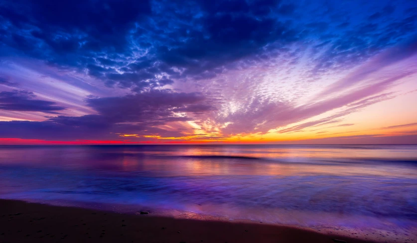 a sunset is seen over the water at the beach