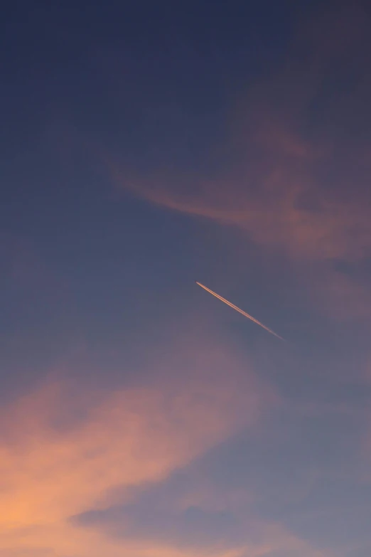 an airplane in the sky just after sunset