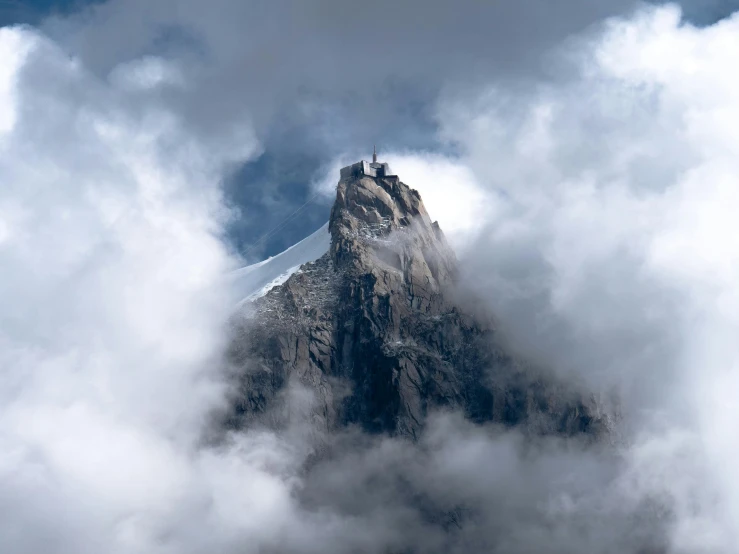 a view of a snowy mountain from the clouds