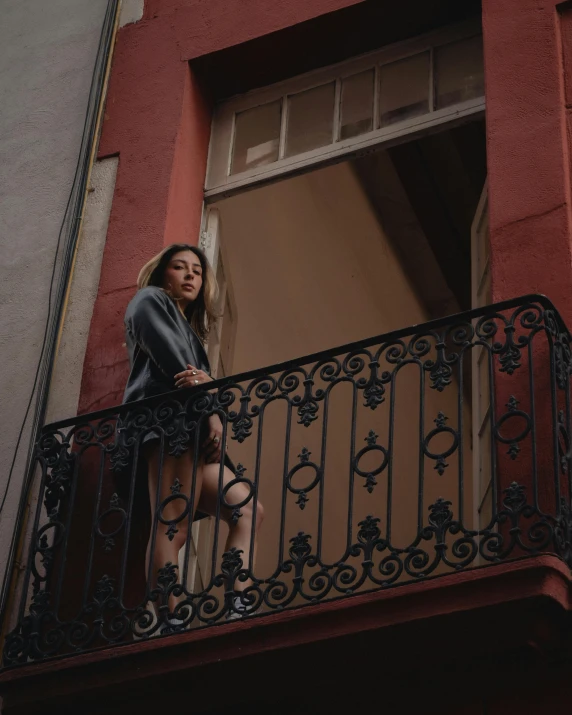 a woman standing in the window of a building