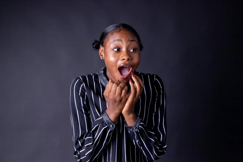 an african american woman covers her mouth as she poses for the camera