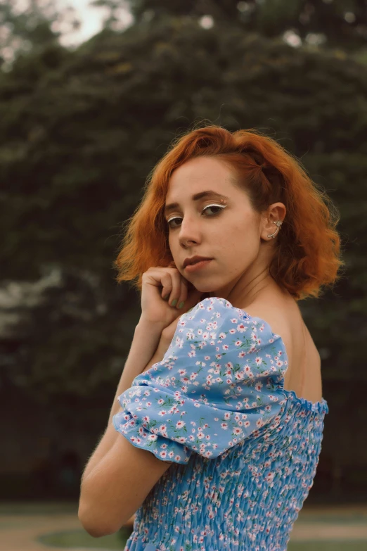 the woman is posing in front of trees