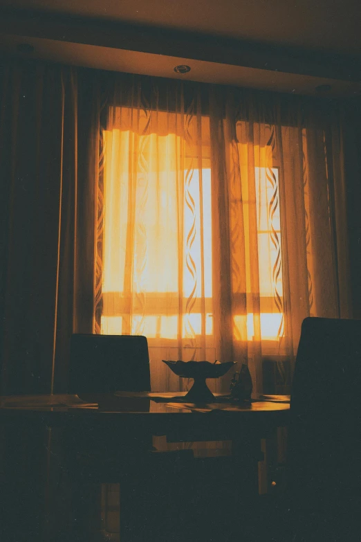 a bright room has sheer curtains and a lamp