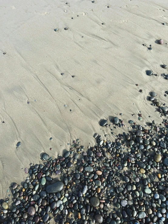 a lot of rocks on a sandy beach