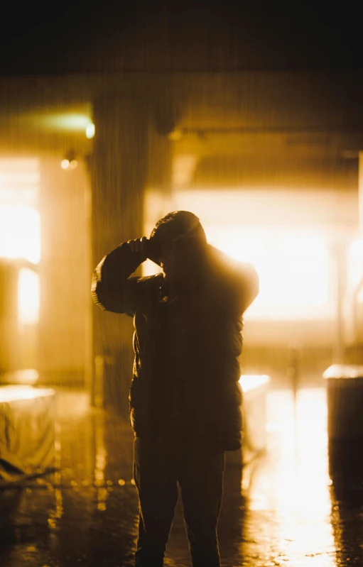 a man stands under an umbrella while the sun is setting