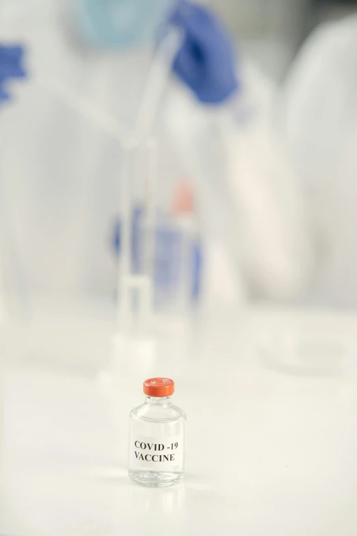 some vials containing medicine with a bottle of liquid in the foreground