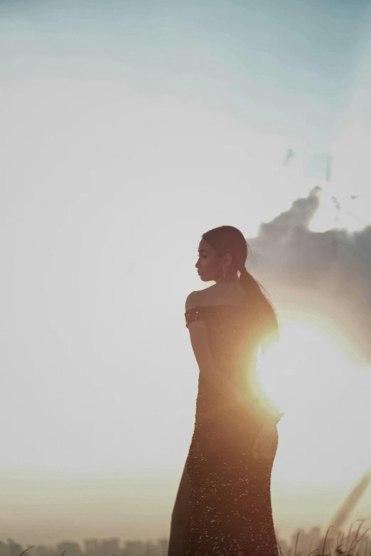 a woman in the middle of a field at sunset