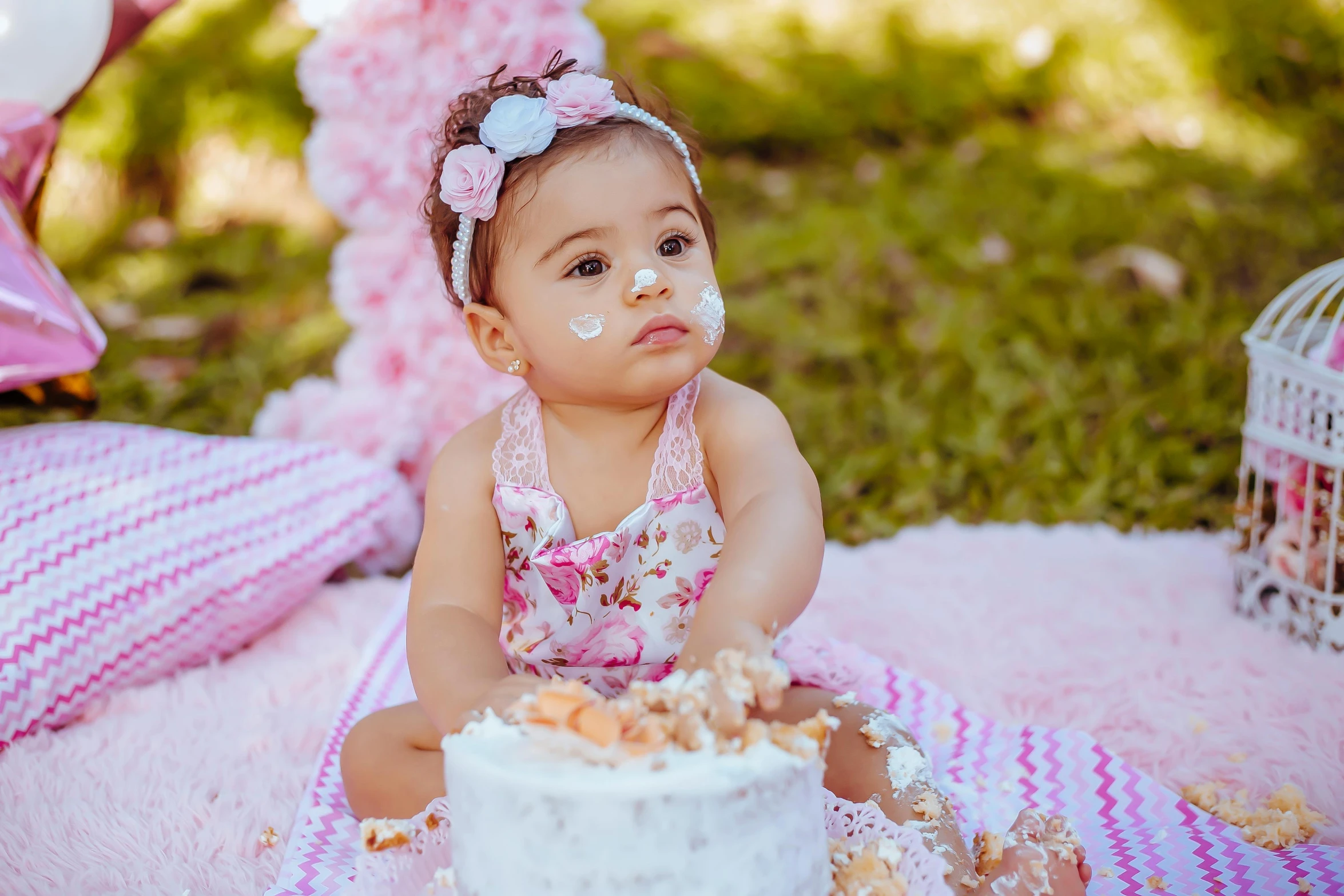 a little baby girl sitting in front of a cake