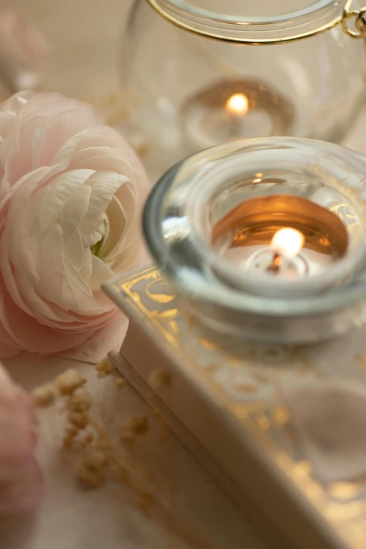 a candle is lit next to some roses