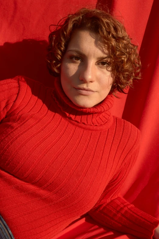 a  wearing a red sweater posing for the camera