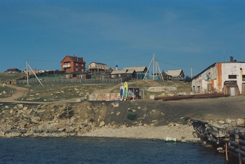 several small houses sit on a rocky hill above the water