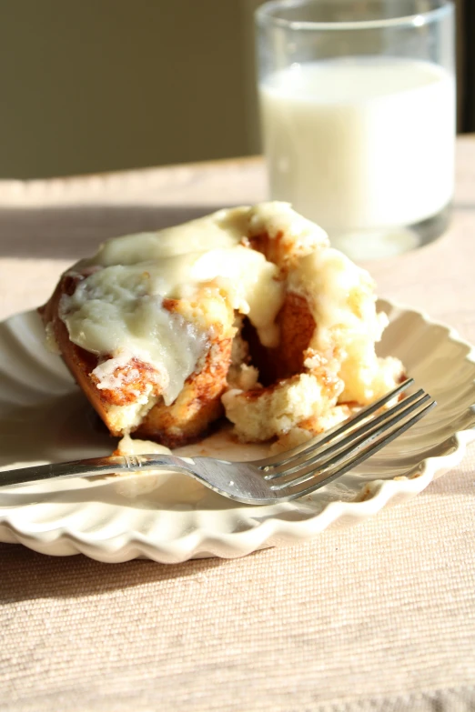 a small meal on a plate with a fork and glass of milk