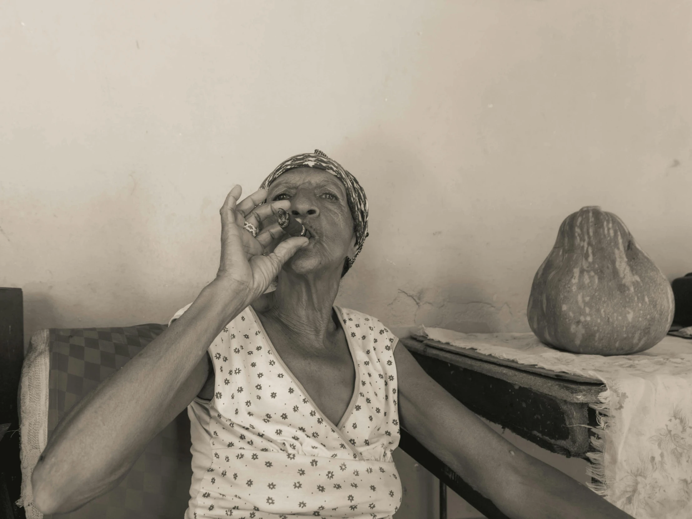 an older woman in a hat putting soing up to her mouth