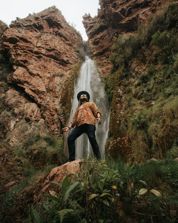 a person standing in front of a large waterfall