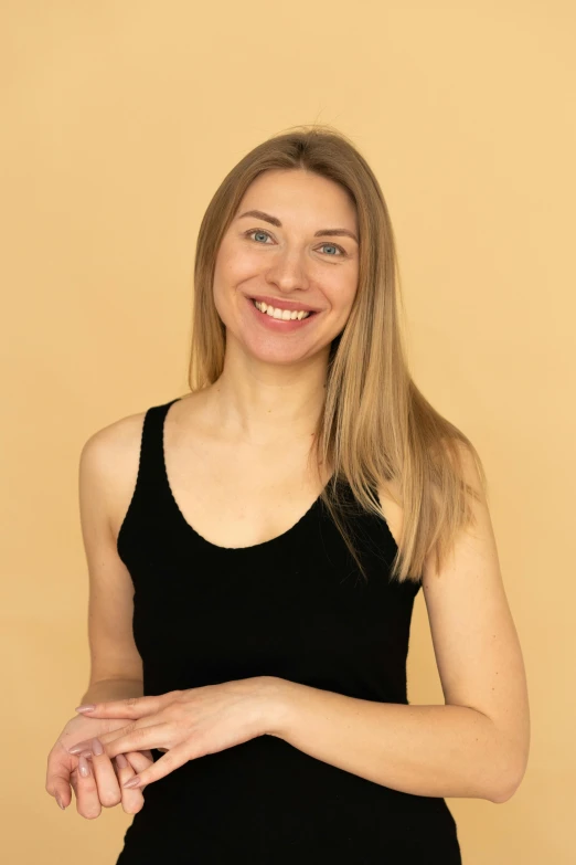 a woman with a smile in front of a brown background