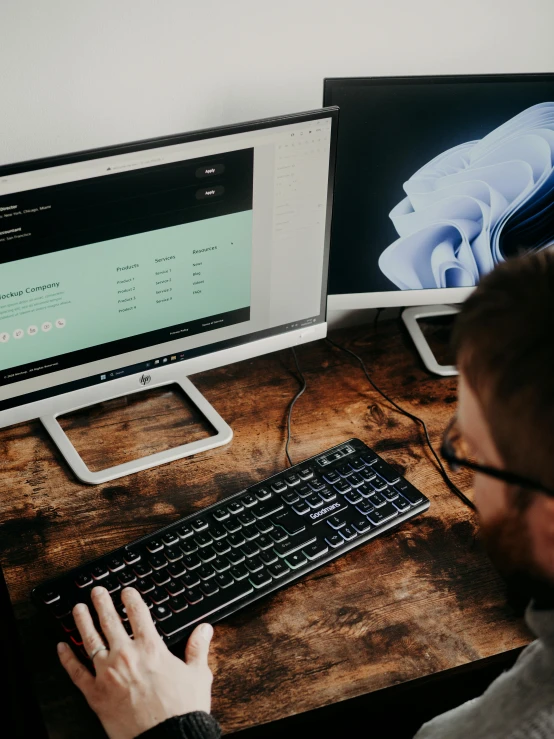 a man is looking at a computer monitor with another man on it