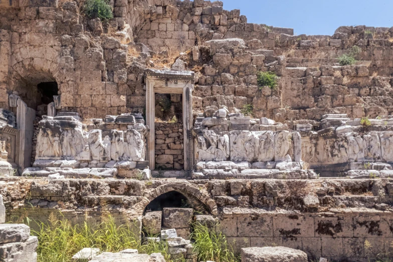 an old ruin with several statues and carved pillars in it