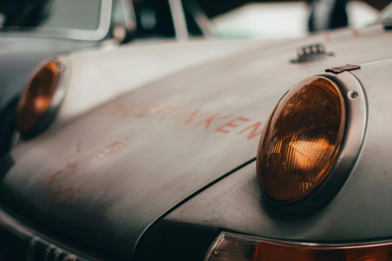 closeup of the headlight and front bumper of an old car