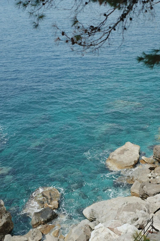 a woman with an umbrella is sitting near the water