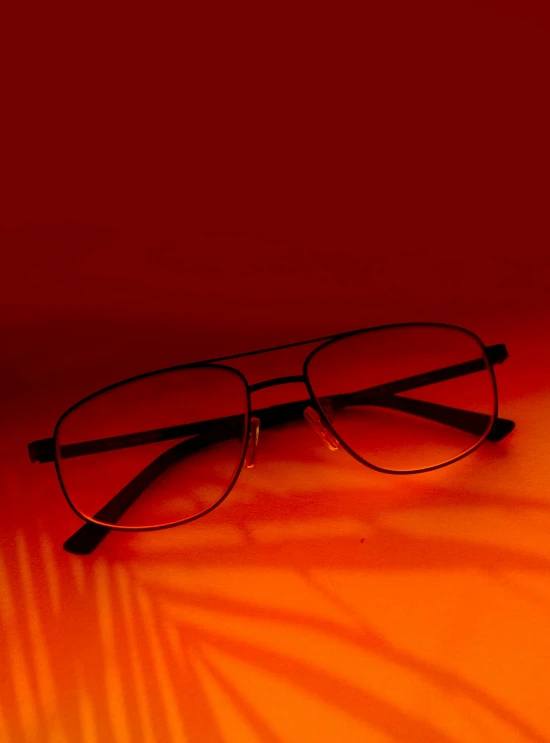 glasses on an orange ground with light behind them