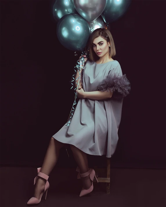 woman holding balloons and shoes, posing for the camera