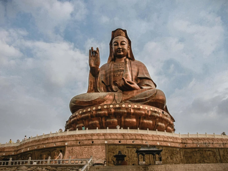 large buddha statue sitting on top of a brown platform