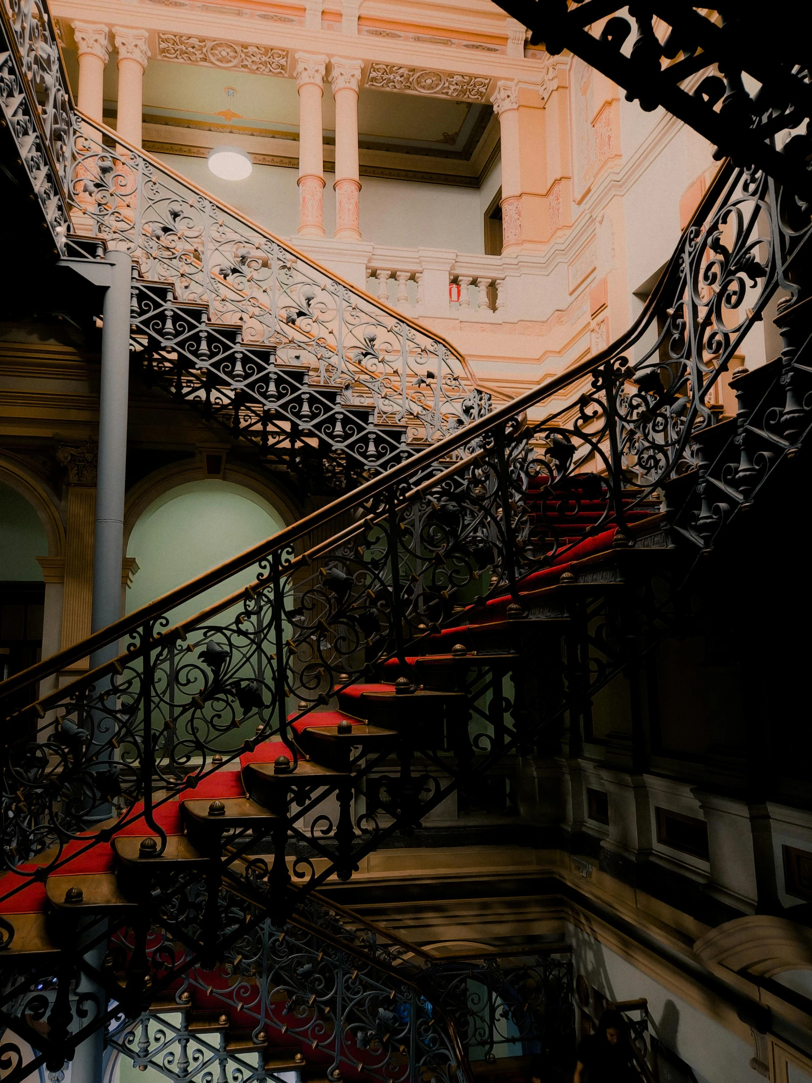 a building with an intricate staircase and wrought iron railing