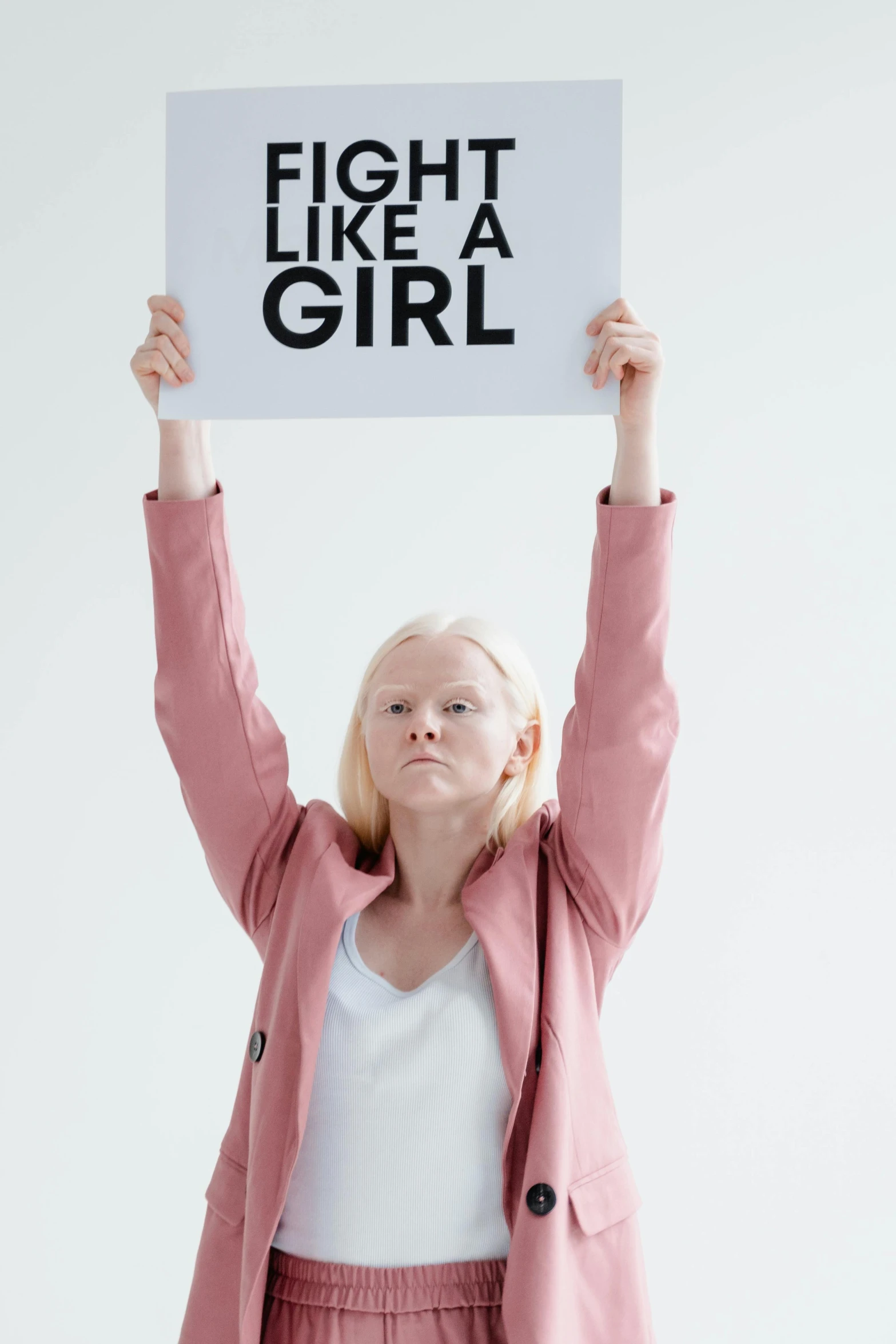 a woman holding up a sign that says fight like a girl