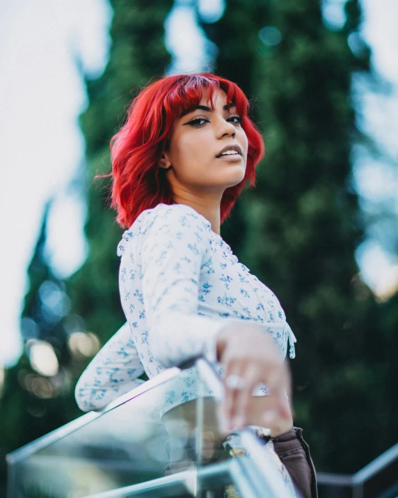 a woman with red hair standing on a balcony