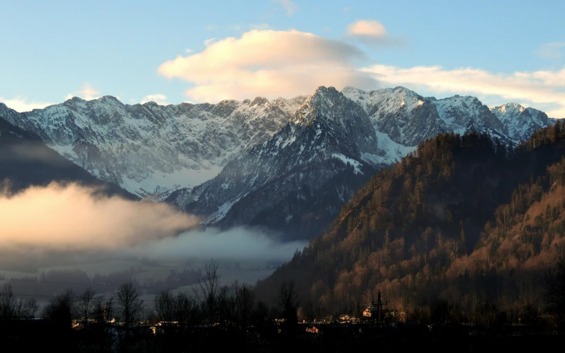 snow covered mountains surrounded by a cloud