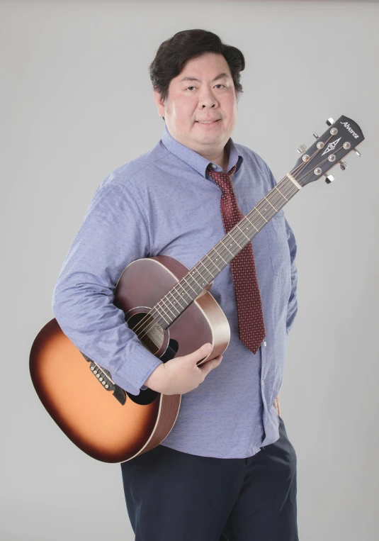 a man holding an acoustic guitar in his hand