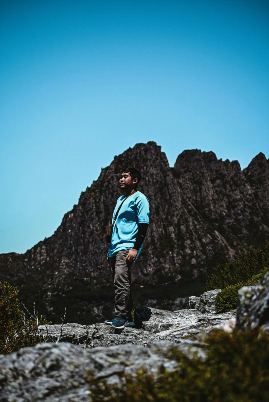 a man stands on a mountain looking off into the distance