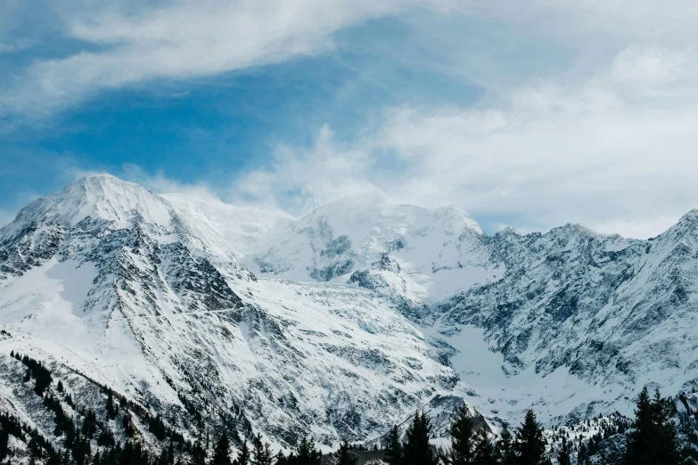 the snow - covered mountains are visible under clouds