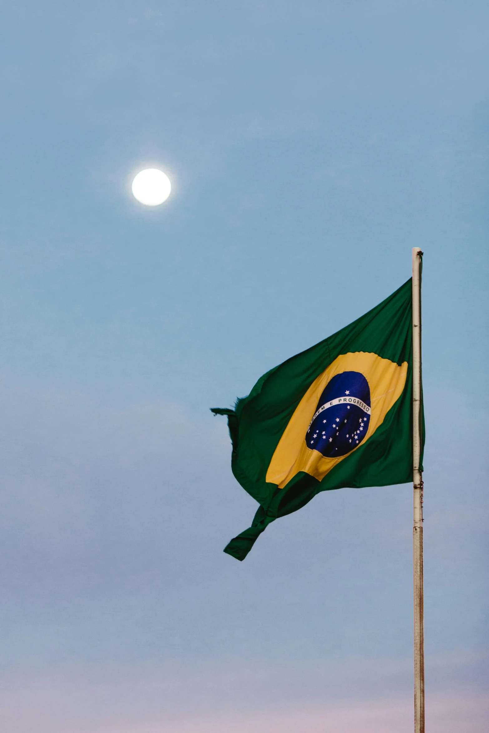 the flag is waving at sunset in front of the moon