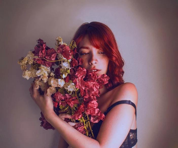 a woman holding flowers over her face